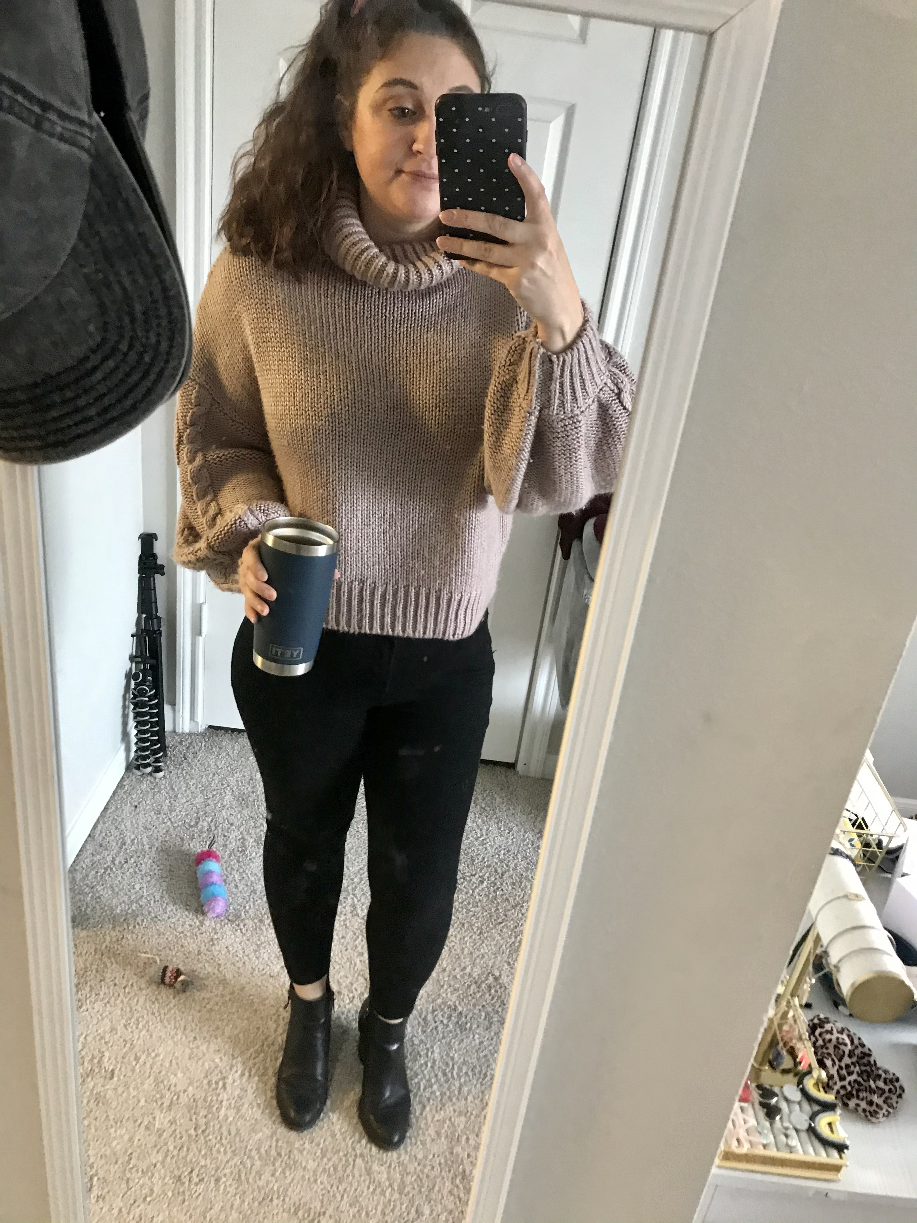 girl with hair up in purple turtleneck and black jeans
