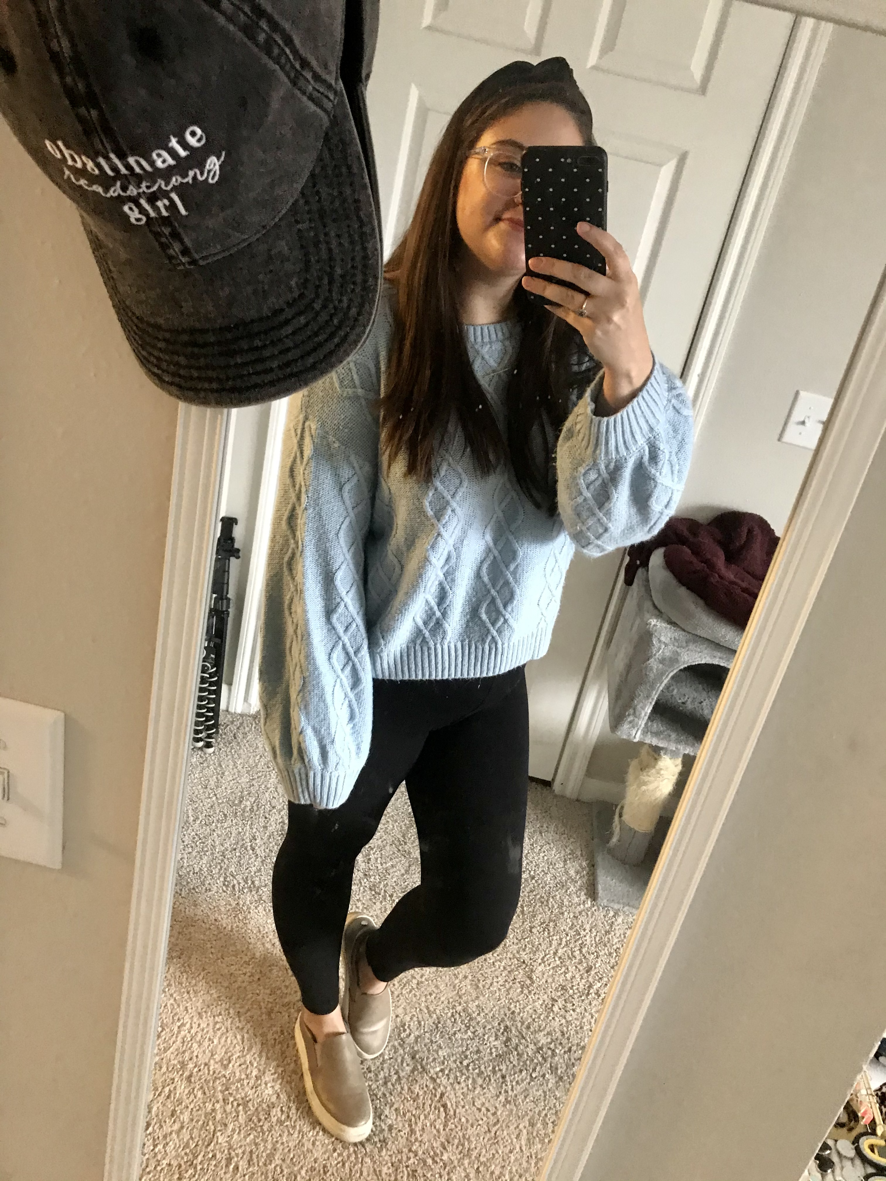 Girl in blue sweater and black leggings with grey slip on sneakers and black knot headband