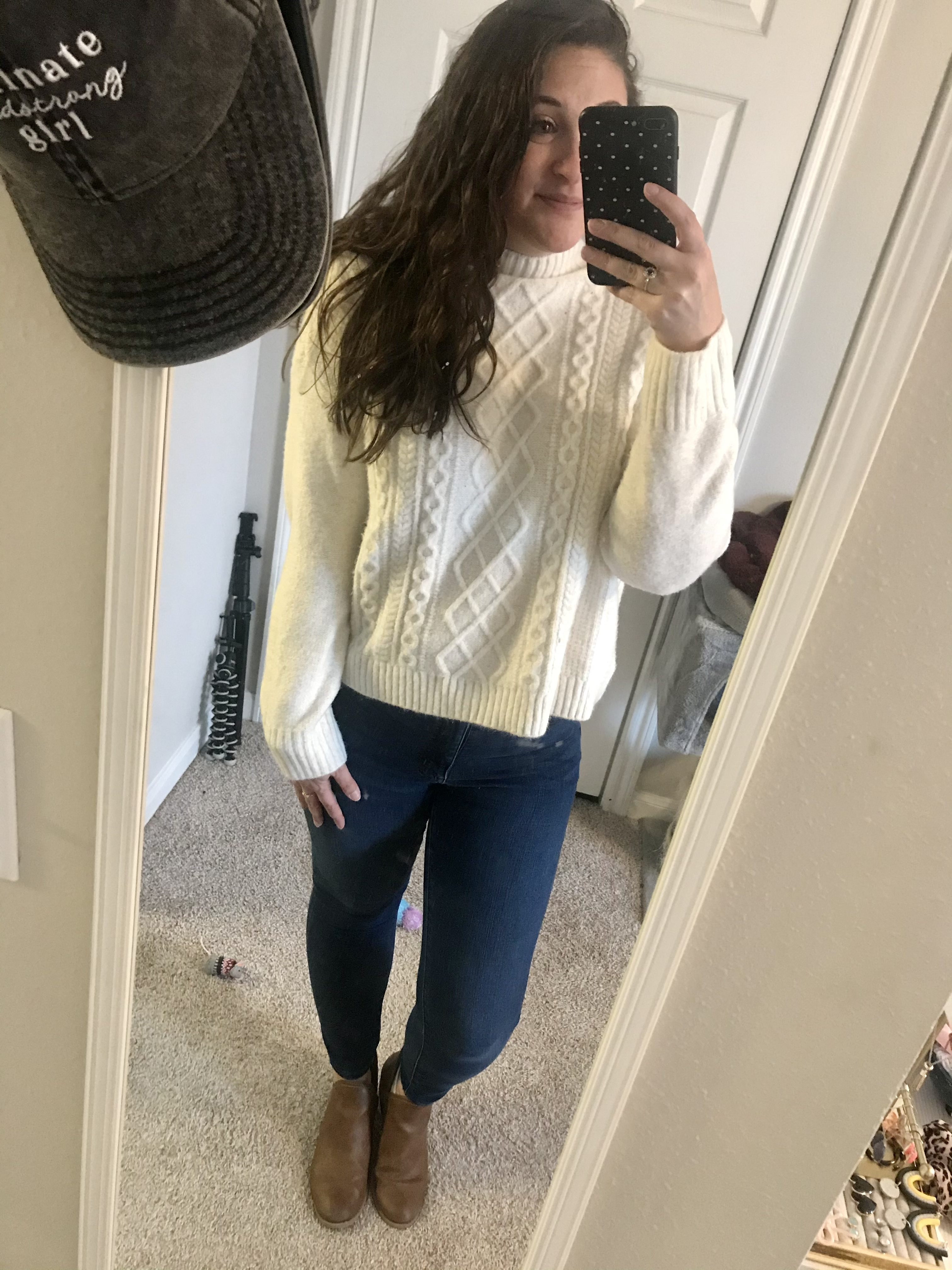 Girl in white turtleneck sweater with blue jeans and brown boots